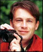 Chris Packham with a pair of binoculars